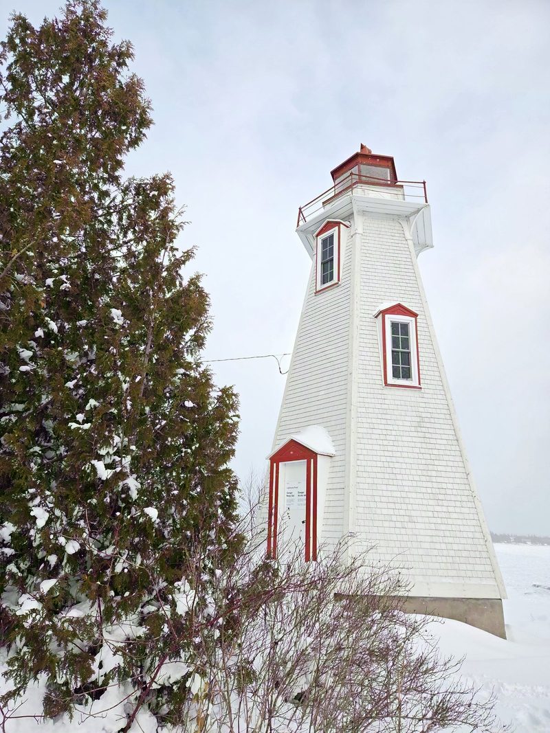 Big Tub Lighthouse in deep snow under a flat white January sky