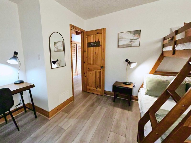 Bosco bedroom with a twin over a double bunk, pine door and desk nook