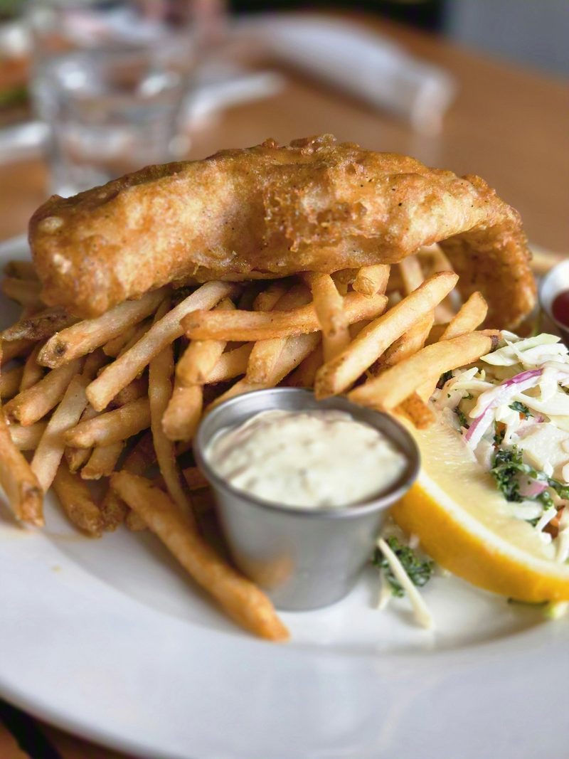 Battered fish and fries with tartar sauce on a plate at the Green Door Café