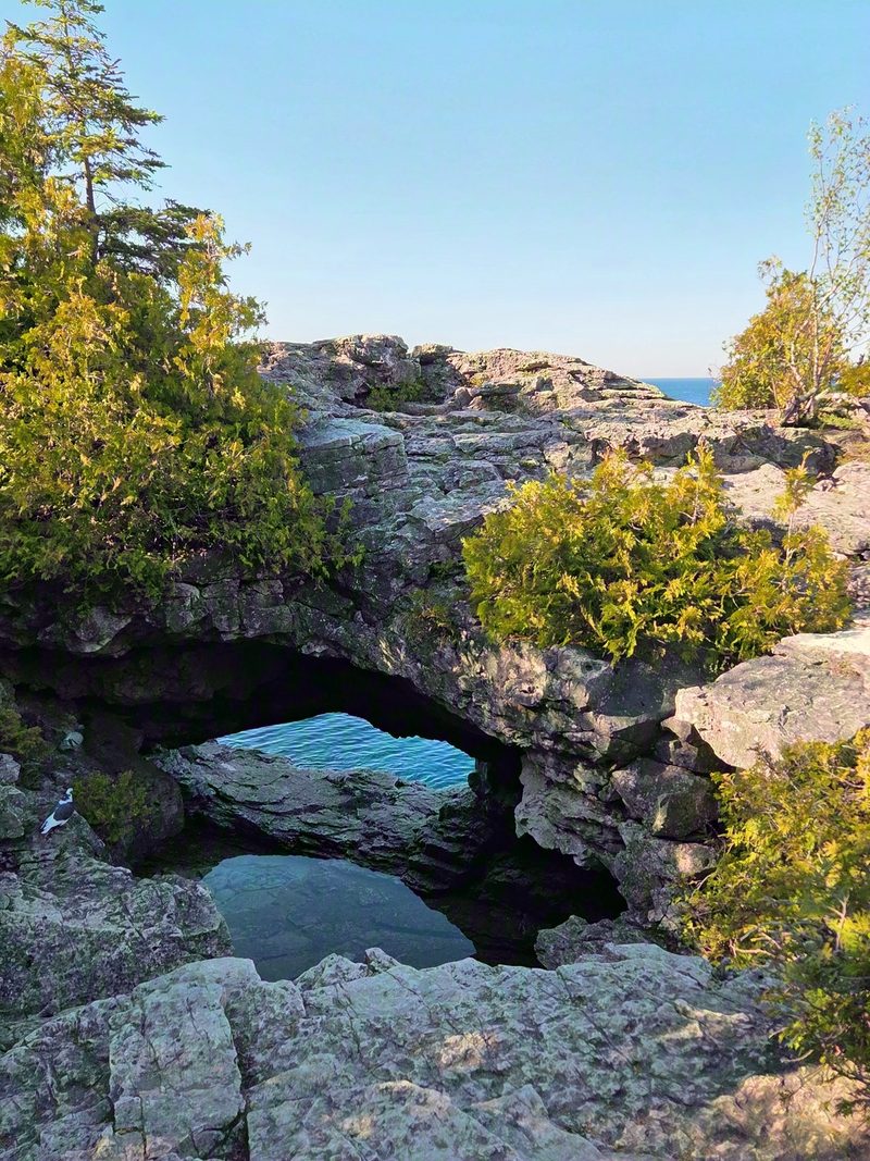 The natural limestone arch beside the Grotto, seen from the clifftop above the water