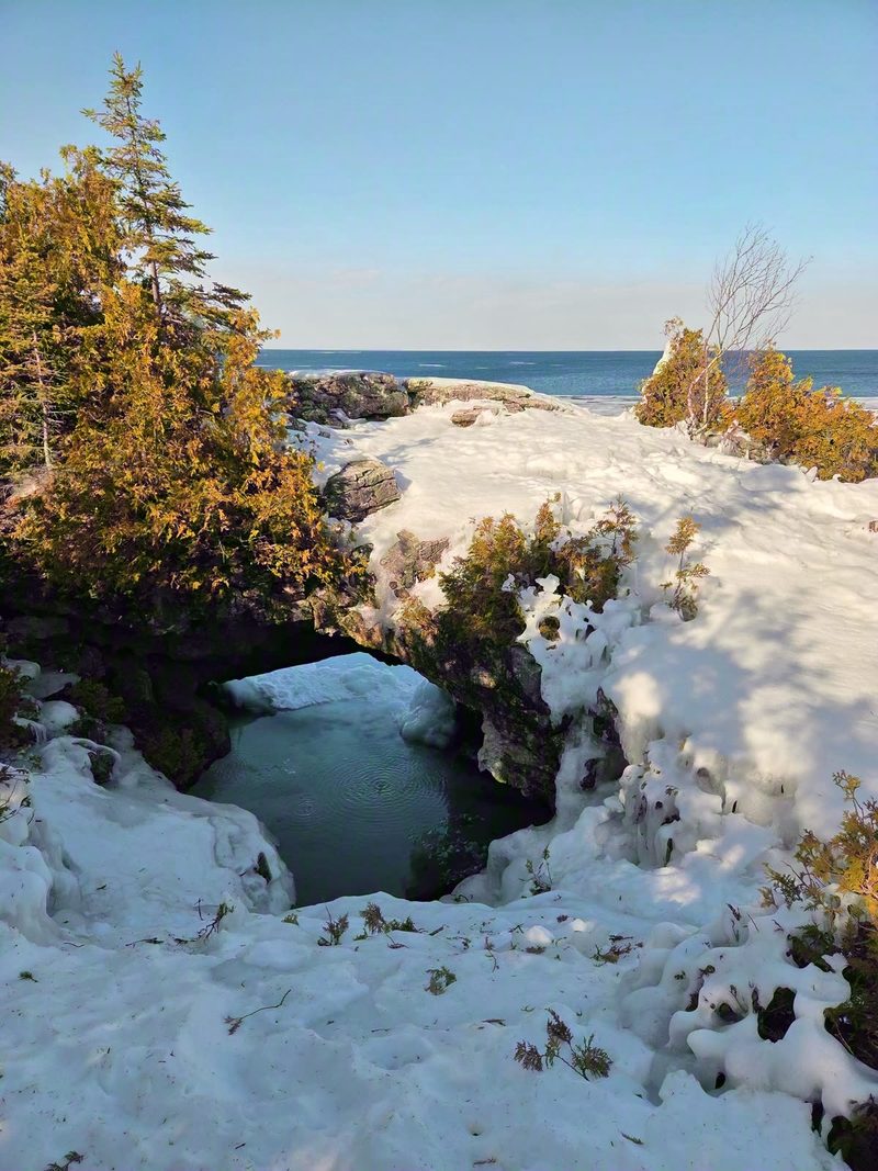 The Grotto under snow with its turquoise pool showing through the ice