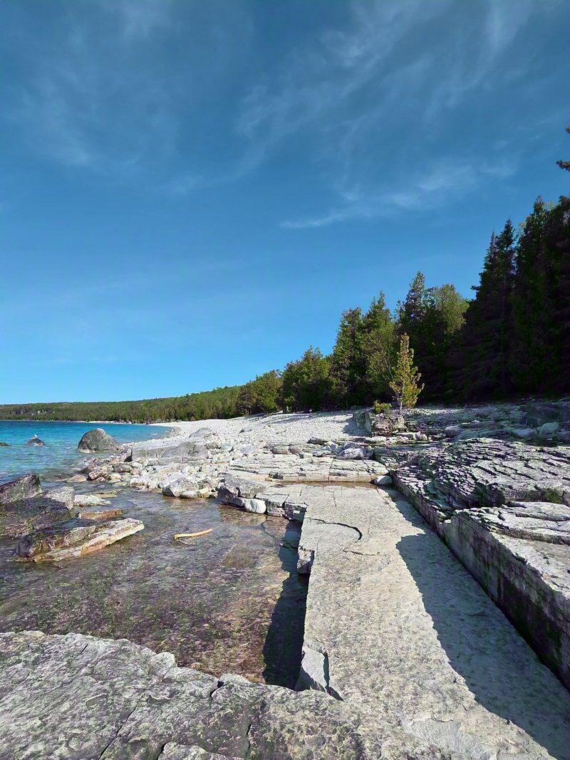 The limestone shelf and white cobble shoreline at Halfway Log Dump above clear turquoise water