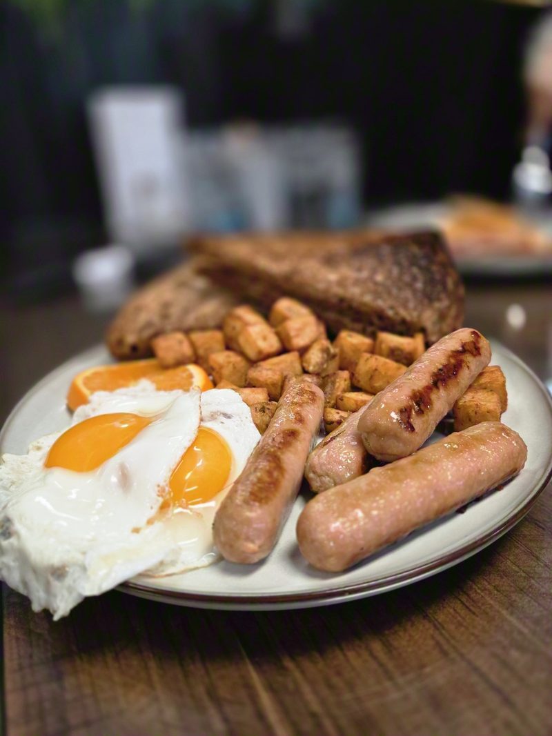 A plate of sausages, fried eggs, home fries and toast at the Hungry Hiker