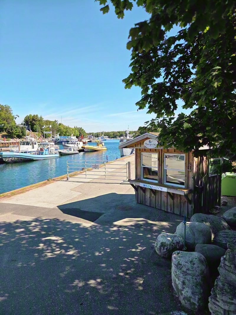 The boardwalk curving around Little Tub Harbour past moored boats on a summer afternoon