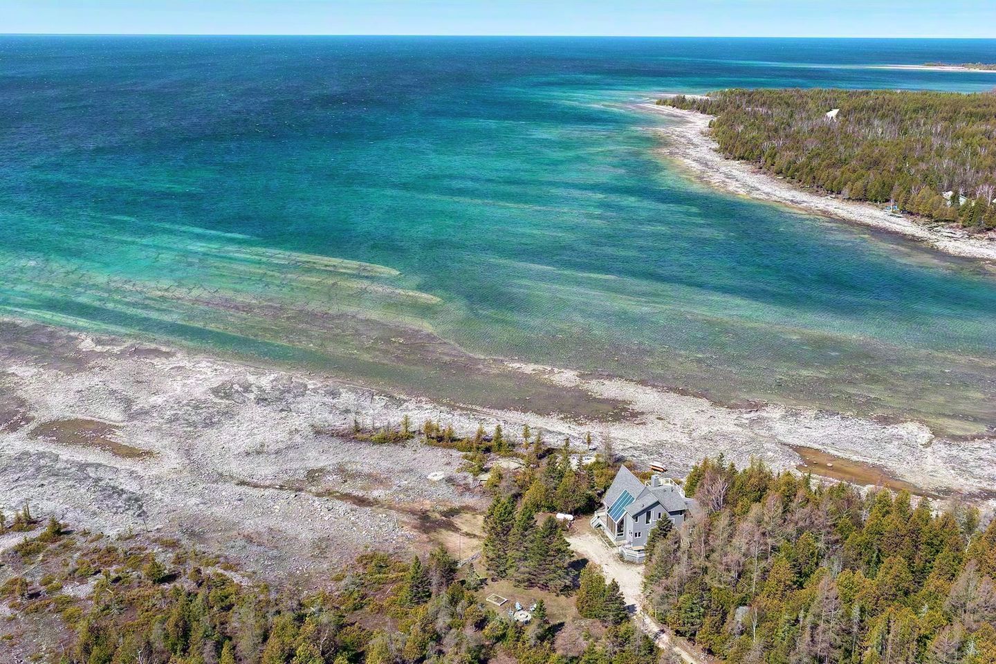 Aerial view of Casolena and its private limestone shoreline on turquoise Lake Huron