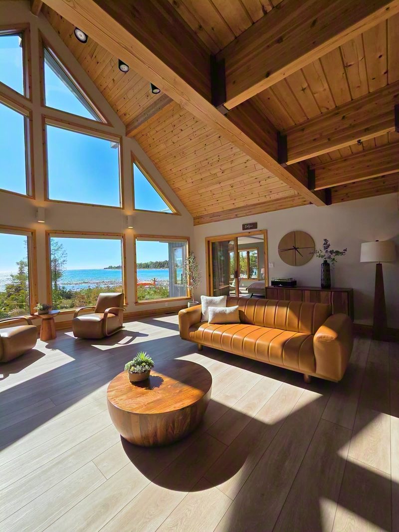 Sunlight pouring through the cathedral windows across the leather sofa and wood floors